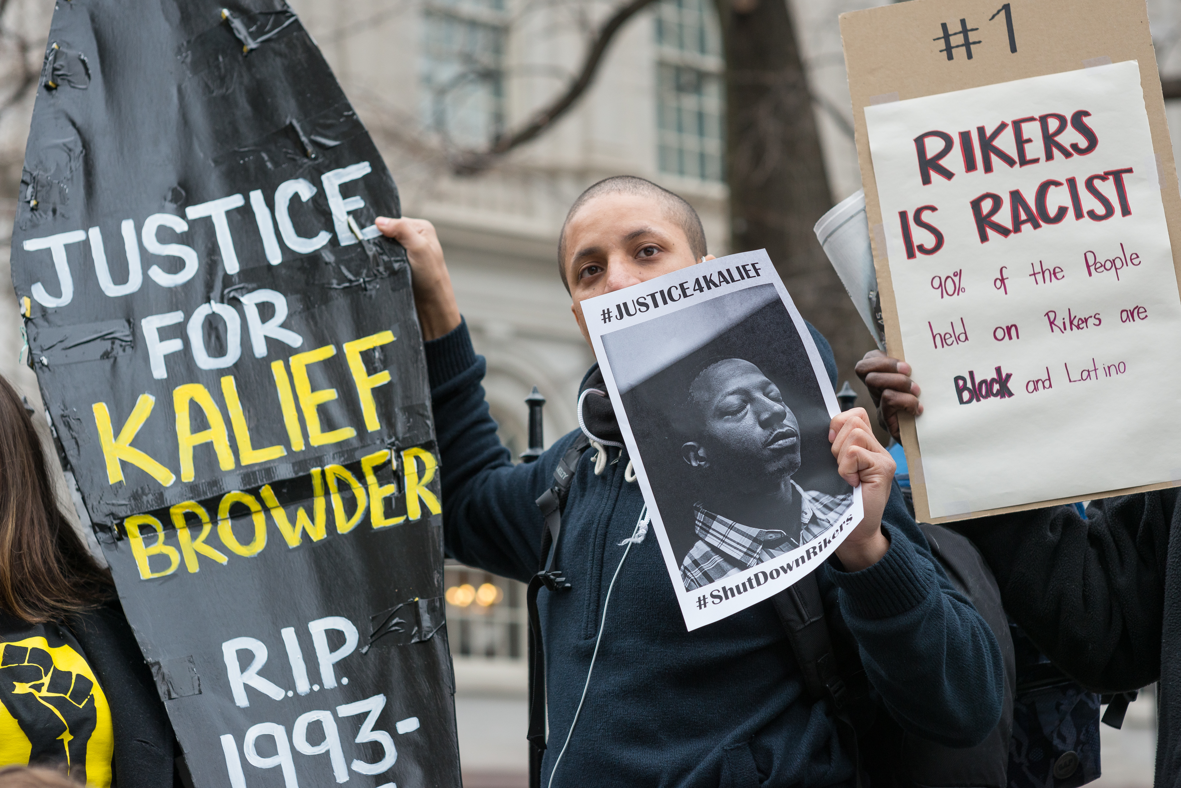 Demonstrators hold aloft a symbolic coffin bearing Kalief...